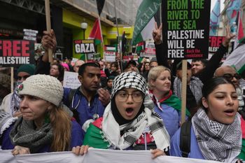 Pro-Palestinian protesters hold up banners, flags and placards during a demonstration in London, UK.