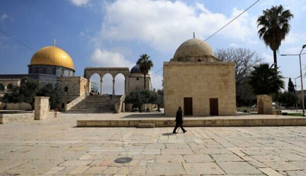 A man walks past the Dome of the Rock (left) inside the Temple Mount compound in the Old City of Jerusalem, on March 16, 2020.