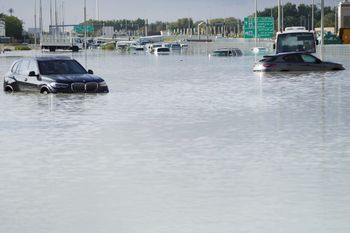 Vehicles sit abandoned in floodwater covering a major road in Dubai, United Arab Emirates.
