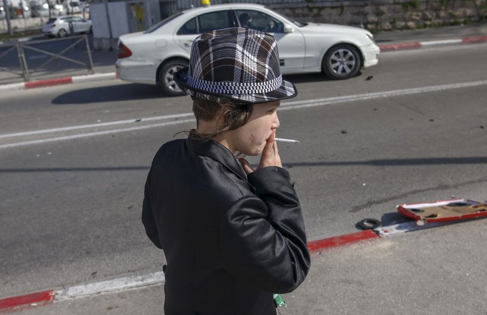 An ultra-Orthodox Jewish boy smokes a cigarette in Jerusalem's neighborhood of Mea Shearim.