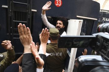 Hafiz Saad Hussain Rizvi waves to supporters while leaving after a case hearing in a court in Lahore, Pakistan, on July 2, 2021.