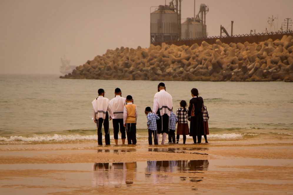 An ultra-Orthodox Jewish family walking on the beach in the southern Israeli town of Ashdod, April 18, 2022.
