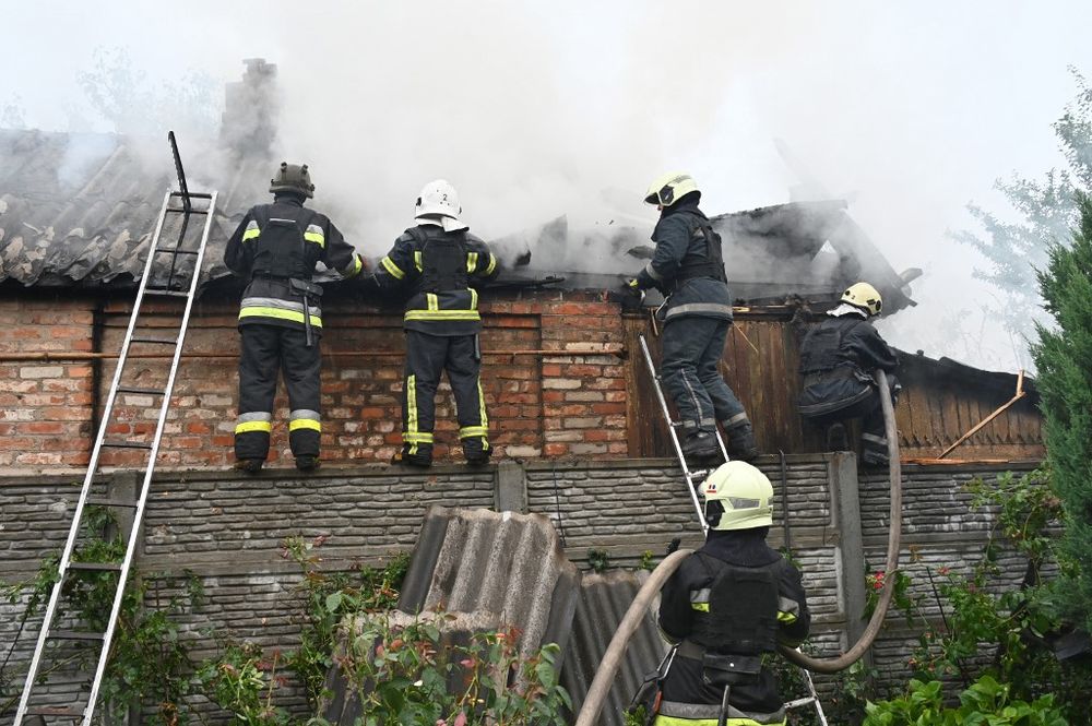 Firefighters work to put out a fire in a house after a suspected missile attack of a residential area in Kharkiv, Ukraine, on July 11, 2022.