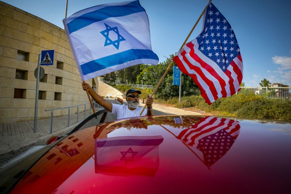 A man waves US and Israeli flags outside the US embassy in Jerusalem on October 27, 2020.