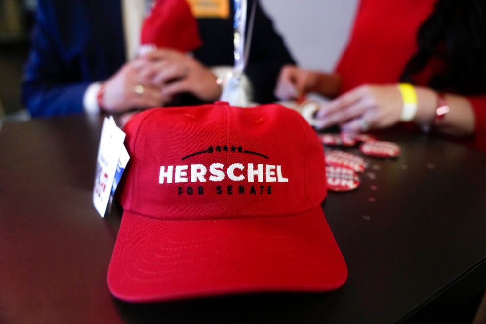 AP Photo/Brynn Anderson A Herschel Walker hat sits on a table during an election night watch party in Smyrna, Georgia, United States.