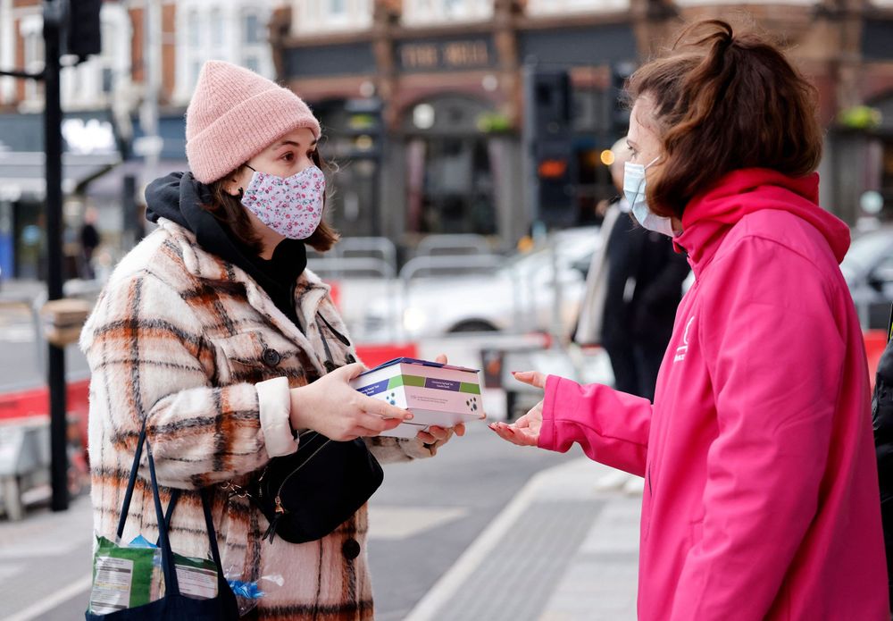 Volunteers hand out boxes of Covid-19 rapid antigen tests, in London, Britain on January 3, 2022.